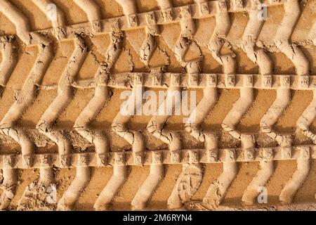 Reifenspuren auf braunem Sand auf der Baustelle Stockfoto