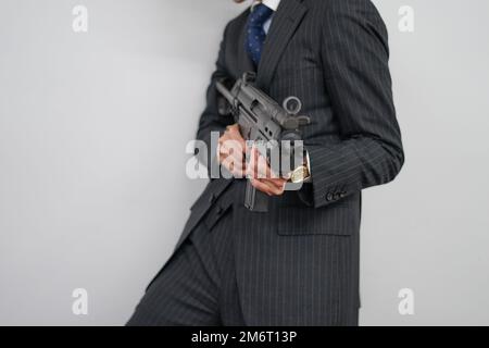 Geschäftsmann mit einem Maschinengewehr zu kämpfen Stockfoto