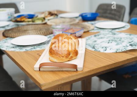 Challah-Brot auf einem Tisch für Sabbat-Essen. Brioche. Hausgemachter weicher, flauschiger weißer Brotlaaf. Stockfoto