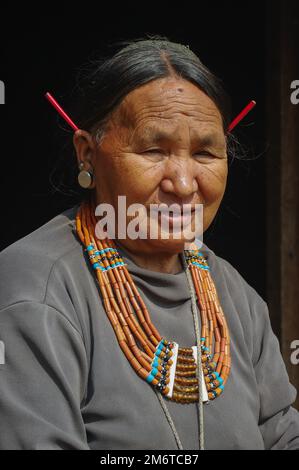 Mon, Nagaland, Indien - 03 11 2014 : Porträt einer Stammesfrau aus Naga Konyak mit wunderschöner traditioneller Halskette und roten Stachelschweinen in den Ohren Stockfoto