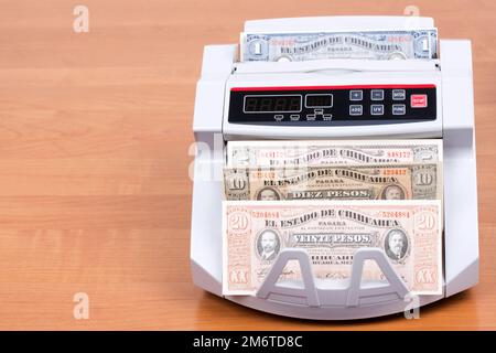 Alte mexikanische Pesos in der Zählmaschine Stockfoto