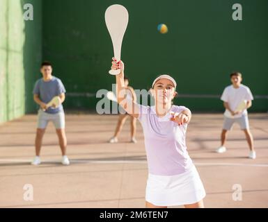 Frau baskische Pelota Spieler schlagen Ball mit Holzschläger Stockfoto