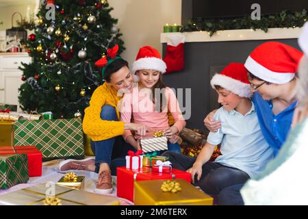 Die kaukasische Familie verbringt Zeit miteinander und packt weihnachtsgeschenke aus Stockfoto