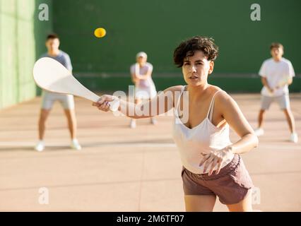 Junge Argentinierin, die im Sommer Pelota an der Freiluftfront spielt Stockfoto