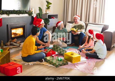 Die kaukasische Familie verbringt Zeit miteinander und packt weihnachtsgeschenke aus Stockfoto