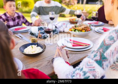Die kaukasische Familie verbringt Zeit draußen und betet vor dem Essen Stockfoto