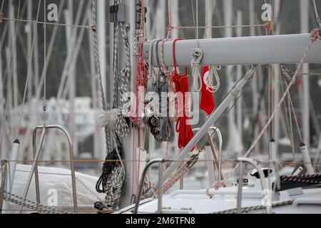 Nautische Seile auf Deck. Details zur Segelausrüstung auf dem Boot. Winde und nautische Seile auf einem Segelboot. Nahaufnahme des Seilknotens, Seemannsknoten Stockfoto