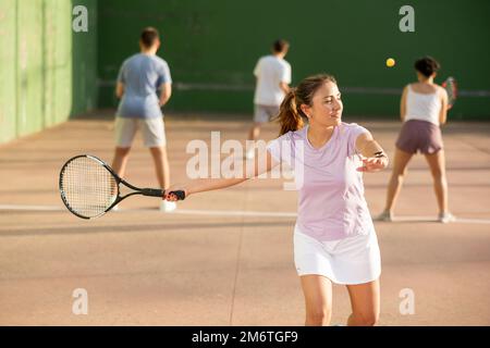 Frau Pelota Spieler schlagen Ball mit Schläger Stockfoto