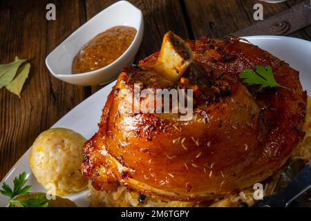 Schweinshaxe mit Sauerkraut und süßem Senf Stockfoto