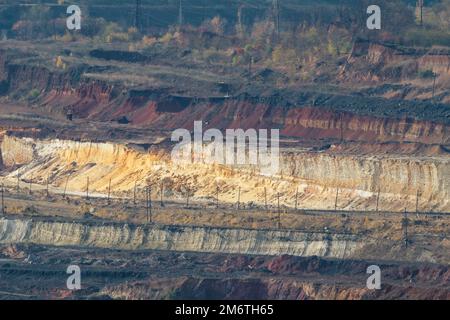 Helle ferne Steinbruchlandschaft bei Tageslicht. Eisenerz-Rasse für den Bergbau. Ukrainische Industrielandschaft Stockfoto