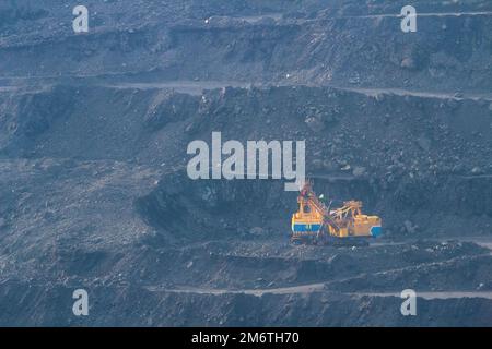 Fernansicht auf dem Bohrfahrzeug. Steinbruch, neblige Industrielandschaft. Eisenerzbergbau in der Ukraine Stockfoto