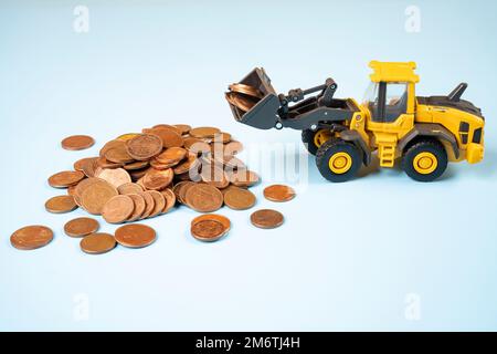 Ein Miniaturmodell eines Bulldozers, der einen Haufen Euro-Cent-Münzen bewegt Stockfoto