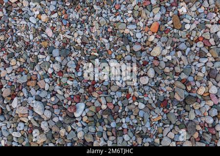 Hintergrund aus Steinen. Natursteine in verschiedenen Farben. Draufsicht. Stockfoto