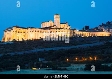 Basilika von Assisi bei Nacht, Region Umbrien, Italien. Die Stadt ist berühmt für die wichtigste italienische Basilika, die dem Hl. Fra gewidmet ist Stockfoto