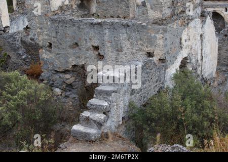 Steintreppe eines zerstörten Hauses. Griechische verlassene Steinhäuser aus dem Kayaköy. Geisterdorf aus Stein, verlassenes griechisches Dorf in Fethiye, Mugla, Stockfoto