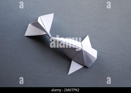 Weißes Papier Fisch Origami isoliert auf einem grauen Hintergrund Stockfoto