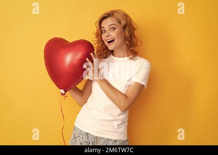 Erstaunt glücklich Rotschopf Mädchen mit Liebe Herz Ballon. Nächstenliebe und Spende Stockfoto