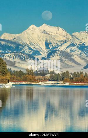 Mond über der flathead River und Mission Berge im Winter in der Nähe von Dixon, Montana Stockfoto