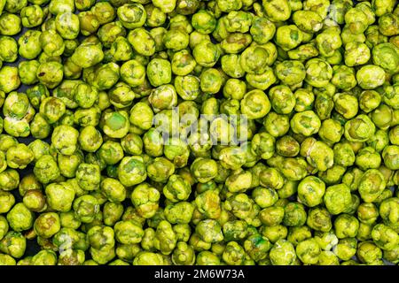 Draufsicht auf einen Haufen trockener, knuspriger, würziger, mit Wasabi beschichteter grüner Erbsen Stockfoto