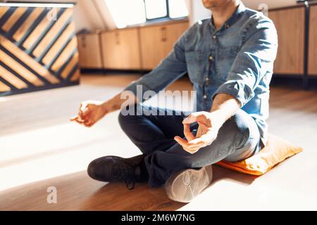 Attraktiver hispanischer Mann in Jeans Freizeit Hemd auf dem Boden zu Hause entspannen Stockfoto