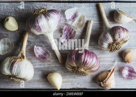 Knoblauch auf Holztisch, Knoblauchzwiebeln und Gewürznelken, flaches Lay Stockfoto