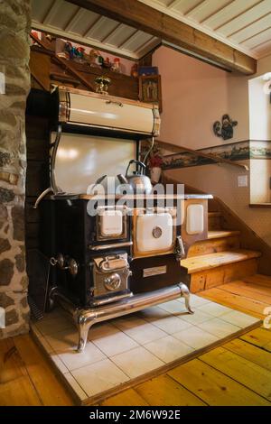 1850er Jahre Sweet Heart Retro-Modell Kochherd handgefertigt von Elmira Herd arbeitet in der Küche in 1980 rekonstruiertem Blockhaus. Stockfoto