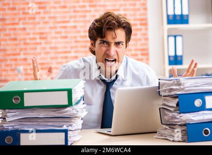 Junge elegante Mann mit zu viel Arbeit unzufrieden Stockfoto