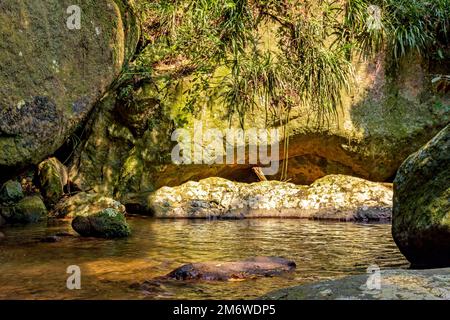 Der Fluss fließt durch die Felsen und den Regenwald auf der Insel Ilhabela Stockfoto