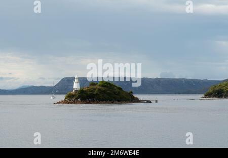 Eine Yacht nähert sich dem Leuchtturm im Hafen von Macquarie in Strhan an der Westküste Tasmaniens. Stockfoto