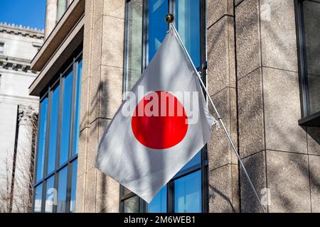 Tokio, Japan. 3. Januar 2023. Eine japanische Flagge, die von einem Bürogebäude abhebt und die Hinomaru-Flagge der Sonne zeigt. Marunouchi ist ein wichtiger zentraler Geschäftsbezirk in der Nähe des Kaiserpalastes und des Bahnhofs von Tokio. Es ist eines der wichtigsten Zentren der japanischen Wirtschaft und Wirtschaft. (Kreditbild: © Taidgh Barron/ZUMA Press Wire) Stockfoto