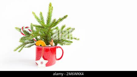 Weihnachtsstrauß in einem roten Becher aus lebender Fichte und festlicher Dekoration und Accessoires, Spielzeug für Stockfoto