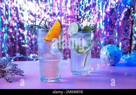 Zwei kräftige und funkelnde alkoholische Punsch sind perfekt für die Weihnachtsfeier. Bunte Cocktails in Gläsern. Frische Feiertagsgetränke. Stockfoto