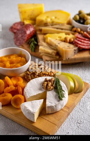 Verschiedene Käsesorten und Aufschnitt. Draufsicht auf weißem Hintergrund. Gemischter Käse mit Nüssen, Cracker, Oliven, Sala Stockfoto