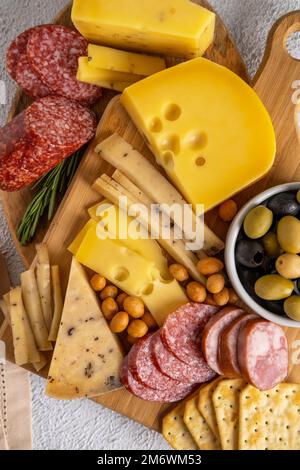 Verschiedene Käsesorten und Aufschnitt. Draufsicht auf weißem Hintergrund. Gemischter Käse mit Nüssen, Cracker, Oliven, Sala Stockfoto