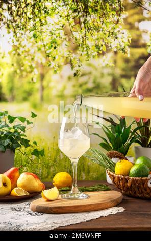 Farbenfroher Sommercocktail auf dem Tisch. Starker Seltercocktail mit Zitrone. Sommerparty-Tisch im Garten Stockfoto