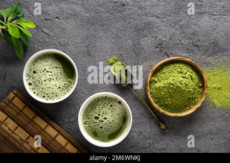 Matcha Teepulver und Teezubehör auf dunklem Hintergrund. Stockfoto