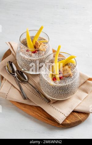 Veganer Chia-Kokosnuss-Pudding mit Mango auf weißem Hintergrund. Gesunde Ernährung, Superfood. Großansicht. Stockfoto