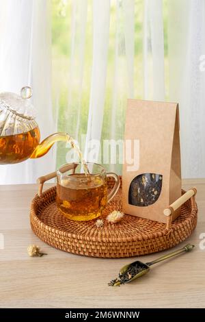 Bio-Teemarkierung und Verpackungsmodell. Grüner Jasmintee in Glas Teekanne auf dem Tisch. Heißer Tee ist in den Glasbechern. Teekanne und Stockfoto