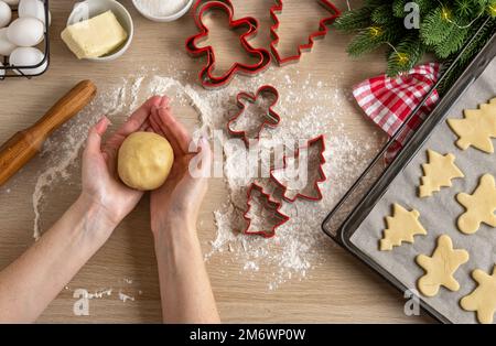 Weibliche Hände halten Keksteig. Wir machen Weihnachtskekse aus traditionellen Zutaten für Lebkekse. Weihnachten Lebkuchen Stockfoto