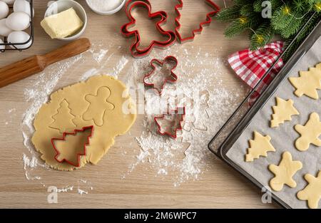 Wir machen Weihnachtskekse aus traditionellen Zutaten für Lebkekse. Weihnachtlicher Lebkuchen-Mann und Tannenbäume auf der Pfanne. Obere V-Achse Stockfoto
