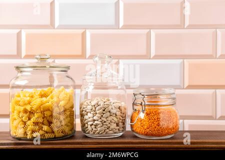 Verschiedene Hülsenfrüchte in Glasgefäßen: Kichererbsen, Pasta, Bohnen, Erbsen, Linsen. Keine Abfalllagerung, plastikfrei. Stockfoto