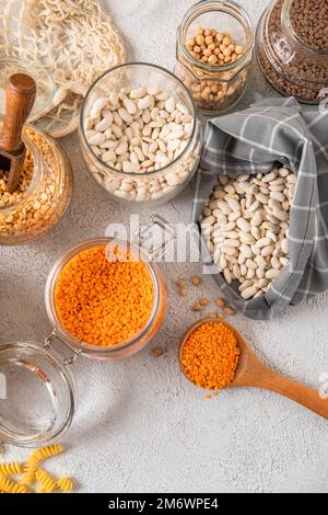 Verschiedene Hülsenfrüchte in Glasgefäßen: Kichererbsen, Pasta, Bohnen, Erbsen, Linsen. Keine Abfalllagerung, plastikfrei. Stockfoto