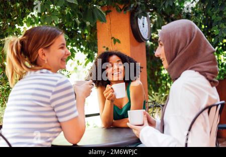 Eine multiethnische Gruppe von Mädchen, die legere Kleidung und traditionellen Hijab tragen und Spaß im Freien haben Stockfoto