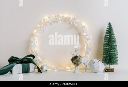 Weihnachtskomposition mit Tannenbaum, Kranz, Hirsch und silbernen Sternen auf weißem Hintergrund. Festliches Winterkonzept. Vorlage Stockfoto