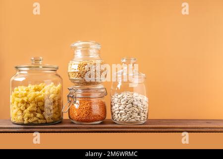 Verschiedene Hülsenfrüchte in Glasgefäßen: Kichererbsen, Pasta, Bohnen, Erbsen, Linsen. Keine Abfalllagerung, plastikfrei. Stockfoto