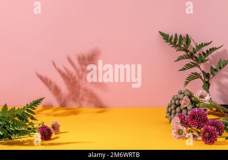 Sommerstil der Präsentation von Kosmetikprodukten auf gelbem und pinkfarbenem Hintergrund mit Blumen. Stockfoto