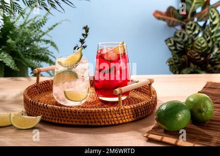 Glitzernde Cocktails mit Eis und Zitrusfrüchten auf einem Korbteller. Beliebte helle, erfrischende alkoholische Getränke. Erfrischende Sommergetränke. Stockfoto