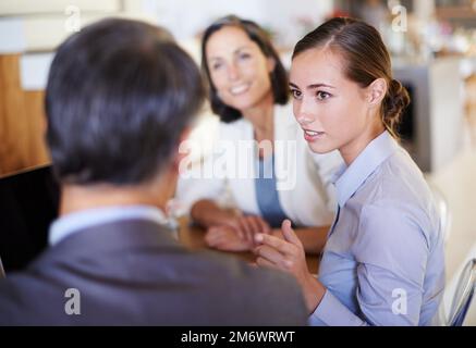 Sehen wir es einmal so: Ein Bild von drei Geschäftsleuten, die ein Meeting in ihrem Büro haben. Stockfoto