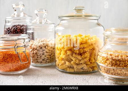 Verschiedene Hülsenfrüchte in Glasgefäßen: Kichererbsen, Pasta, Bohnen, Erbsen, Linsen. Keine Abfalllagerung, plastikfrei. Stockfoto