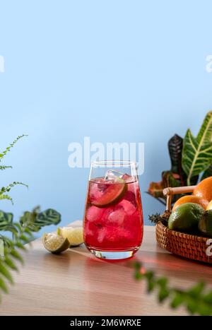 Erdbeercocktail mit Eis auf einem Weidenkorb. Beliebtes, helles, erfrischendes Alkoholgetränk. Erfrischende Sommergetränke mit Humor Stockfoto